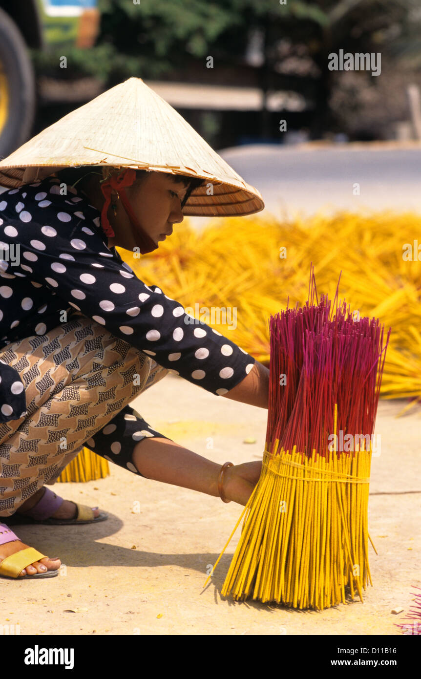 1990ER JAHRE MEKONG VIETNAM FRAU BÜNDELUNG WEIHRAUCH IM MARKTPLATZ Stockfoto