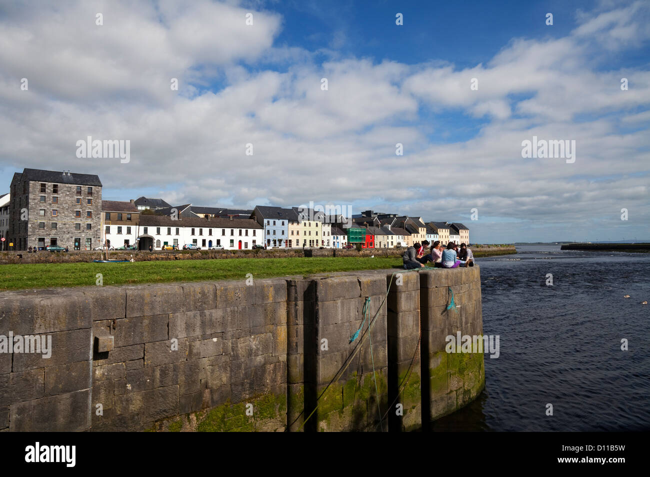 Junge Menschen, die entspannen, The River Corrib fließt zwischen den Long Walk und Claddagh Quay, Stadt Galway, Irland Stockfoto