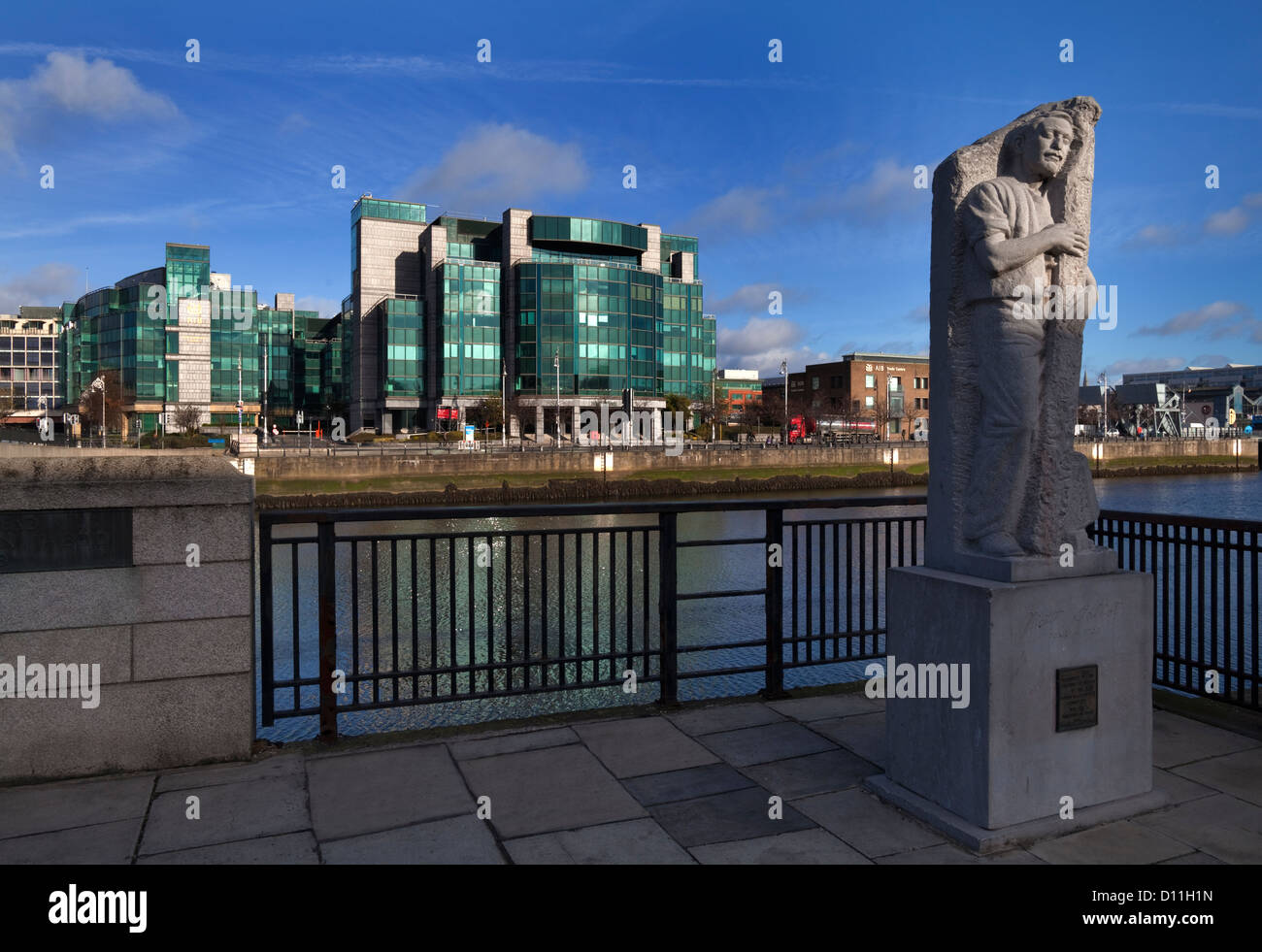Skulptur von Matt Talbot, mit Irish Financial Services Certre (IFSC) über den Fluss Liffey, Stadt Dublin, Irland Stockfoto