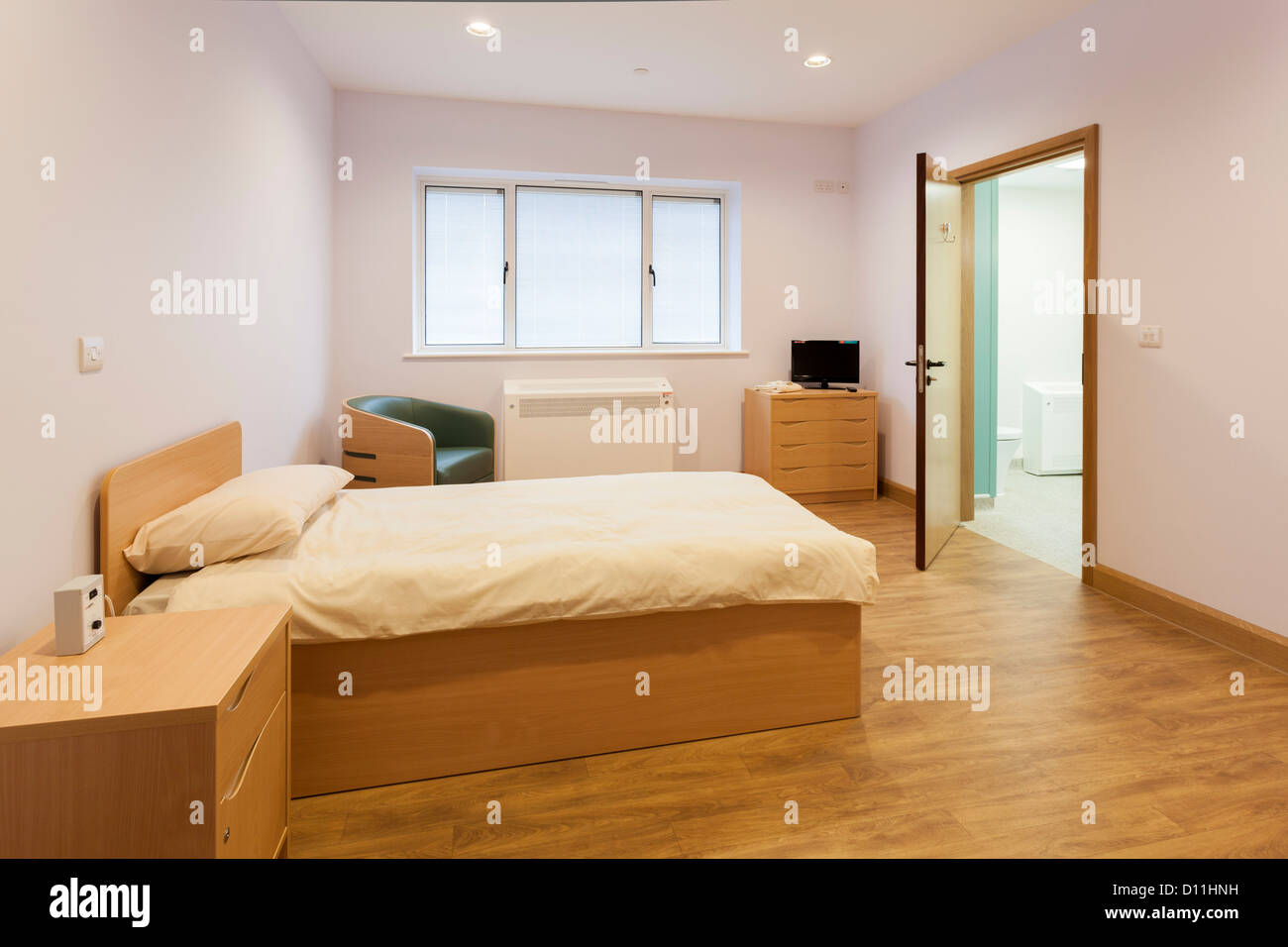 Unbesetzten Pflege zuhause Schlafzimmer mit offener Tür, En-Suite Badezimmer. Stockfoto