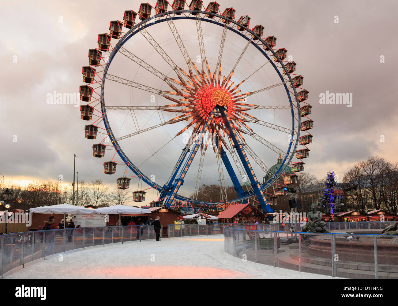 Eis-Eisbahn und Riesenrad an einen traditionellen Weihnachtsmarkt am Abend am Alexanderplatz, Berlin, Deutschland Stockfoto