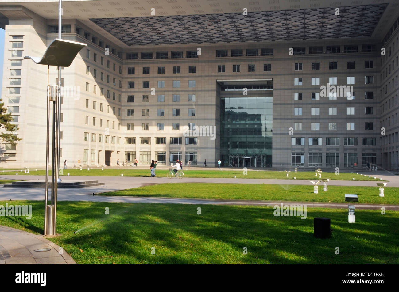 Fußgänger auf einem Pfad vor Gebäude mit einem Glas-Eingang; Peking China Stockfoto