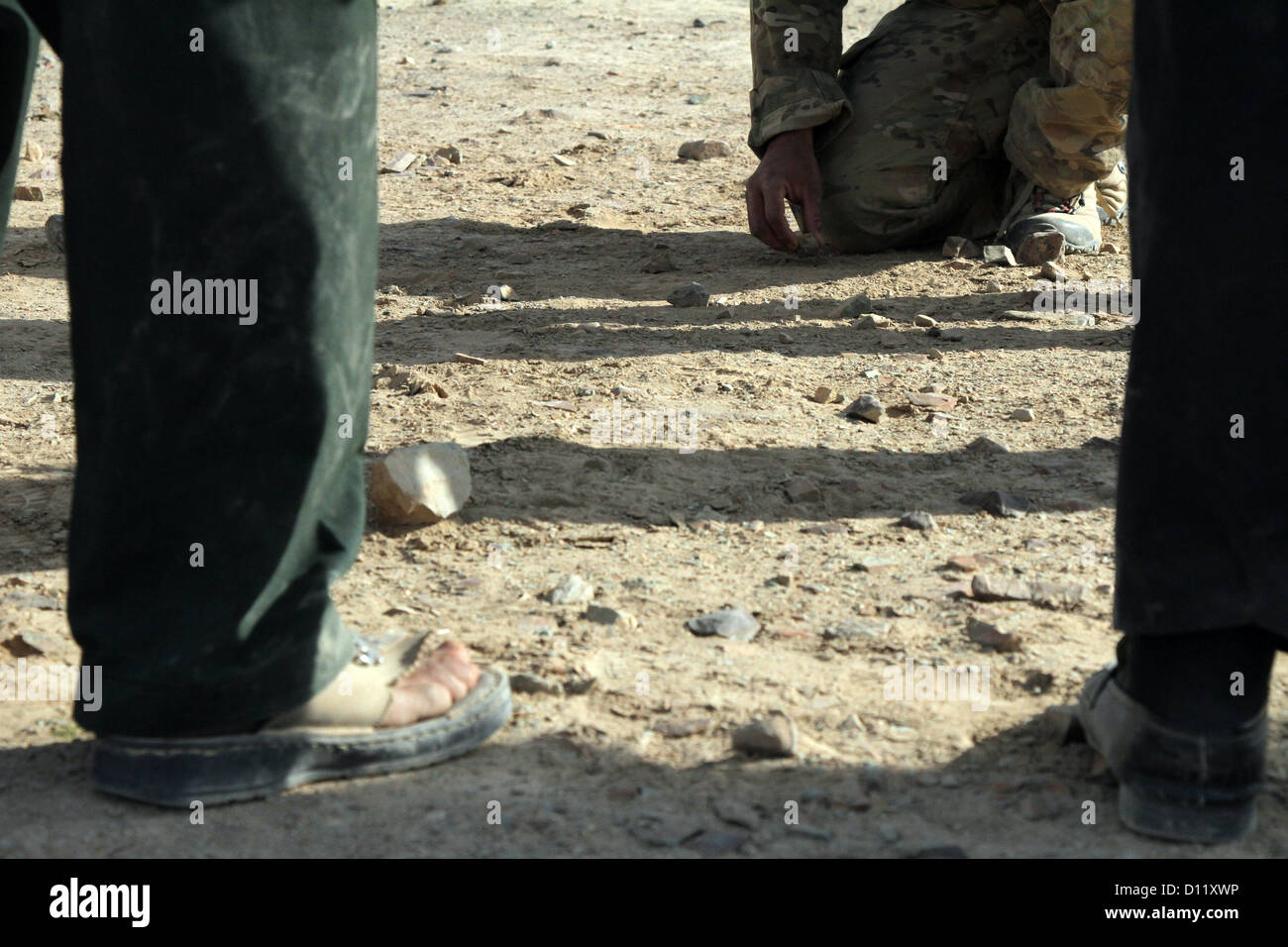 Eine Koalition Kraft Spezialoperationen Teammitglied mit Special Operations Task Force zeigt afghanische Polizei verschiedene Patrouille Formationen mit Felsen dazu mit patrouillierenden Techniken Dez. 4, in der Provinz Farah rekrutiert. Die ALP Rekruten teilgenommen Stockfoto