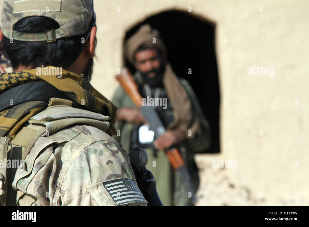 Eine Koalition Kraft Spezialoperationen Teammitglied Special Operations Task Force berichtet afghanische Polizei Rekruten nach dem üben patrouillierenden Techniken Dez. 4, in der Provinz Farah. Die ALP Rekruten teilgenommen patrouillieren Klasse als Bestandteil ihrer Zug Stockfoto