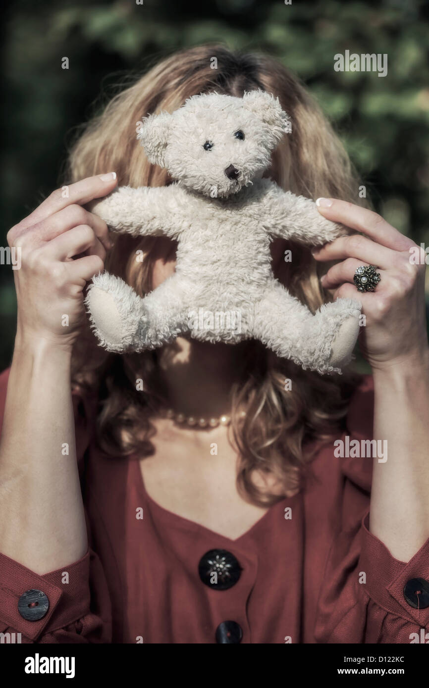 eine Frau verbirgt sich hinter einer weißen Teddybär Stockfoto