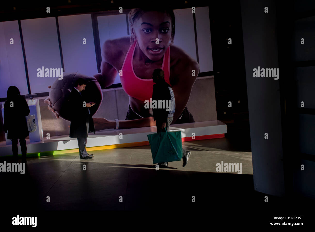 Shopper und Riesen Basketball Sportlerin im Nike Shop am Oxford Circus, Londons. Stockfoto