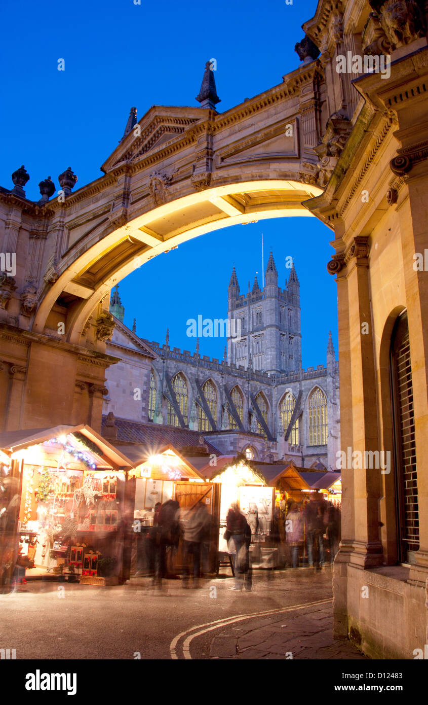 Weihnachten Marktstände durch Bogen mit Bath Abbey im Hintergrund gesehen in der Nacht / Dämmerung / Dämmerung Bad Somerset England UK Stockfoto