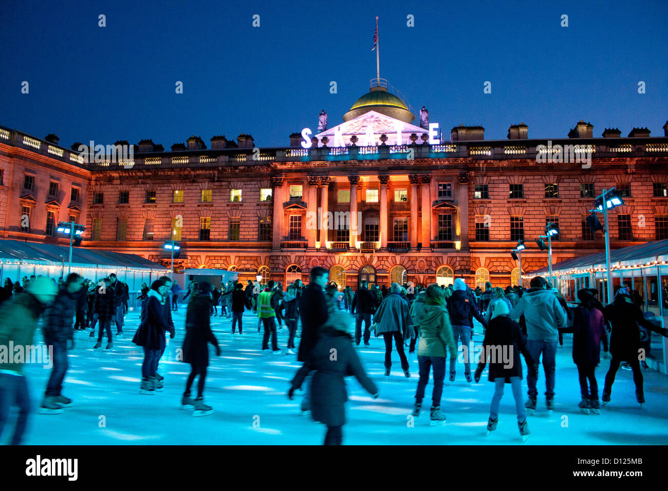 Schlittschuhläufer auf der Eisbahn im Somerset House in der Nacht der Strang London England UK Stockfoto