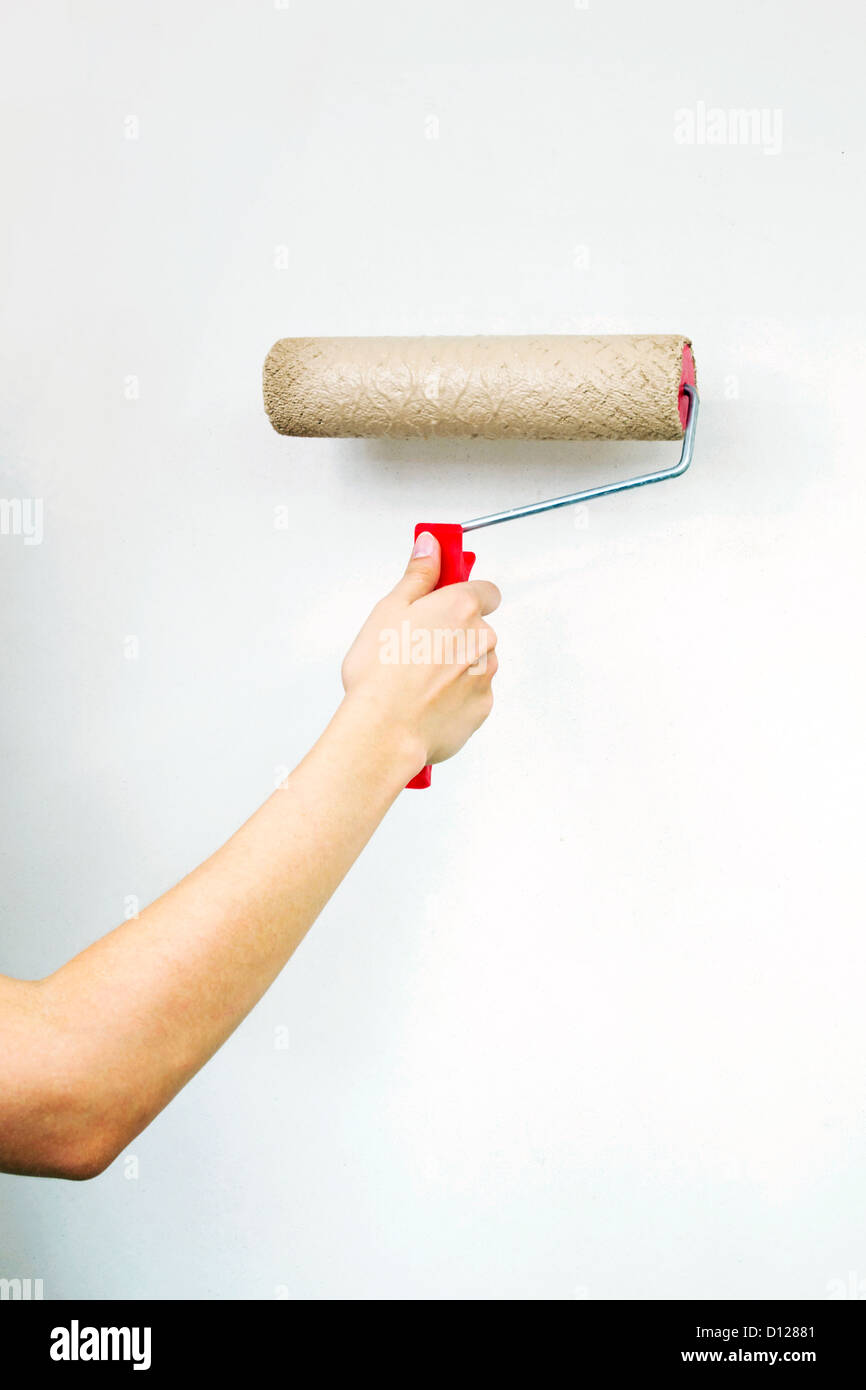 Walze mit Farbe auf weiße Wand Stockfoto
