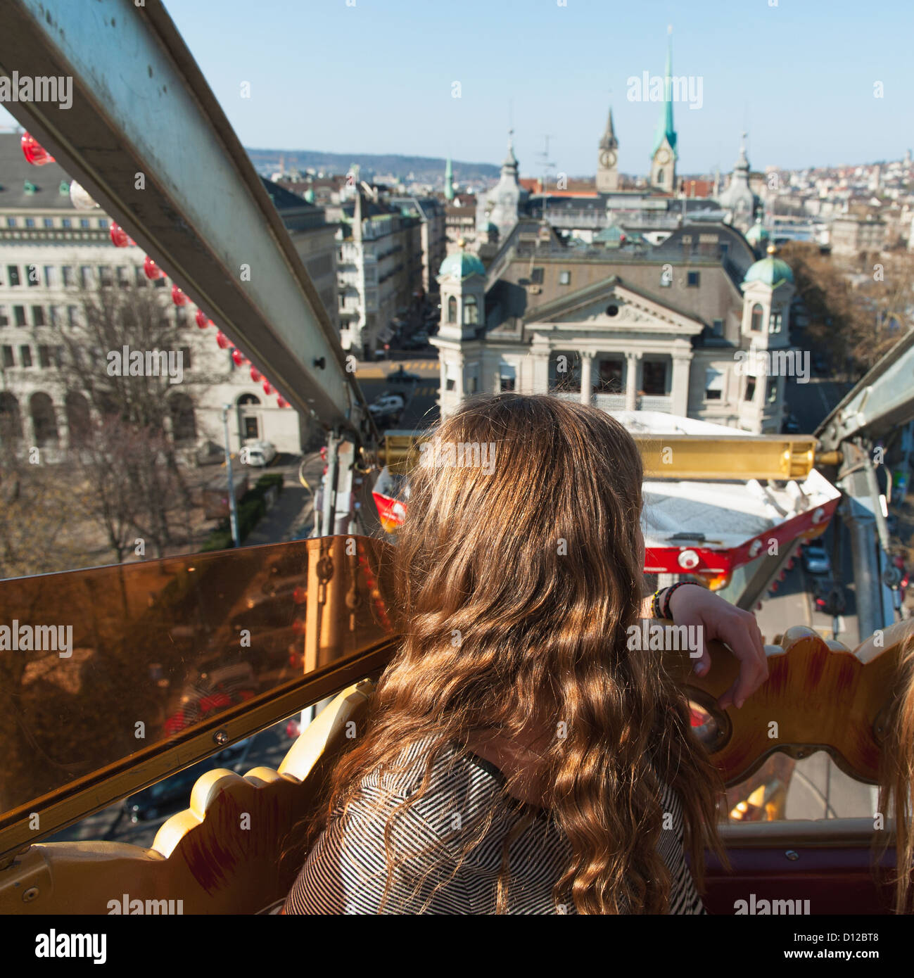 Ein Mädchen über die Schulter auf die Gebäude unten beim Reiten A Riesenrad Rückblick; Zürich Schweiz Stockfoto