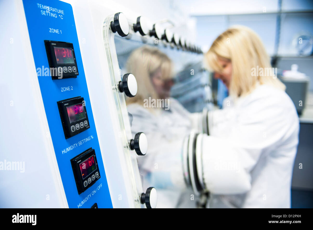 Wissenschaftlerin arbeitet bei Temperatur gesteuert Inkubator in Science-lab Stockfoto