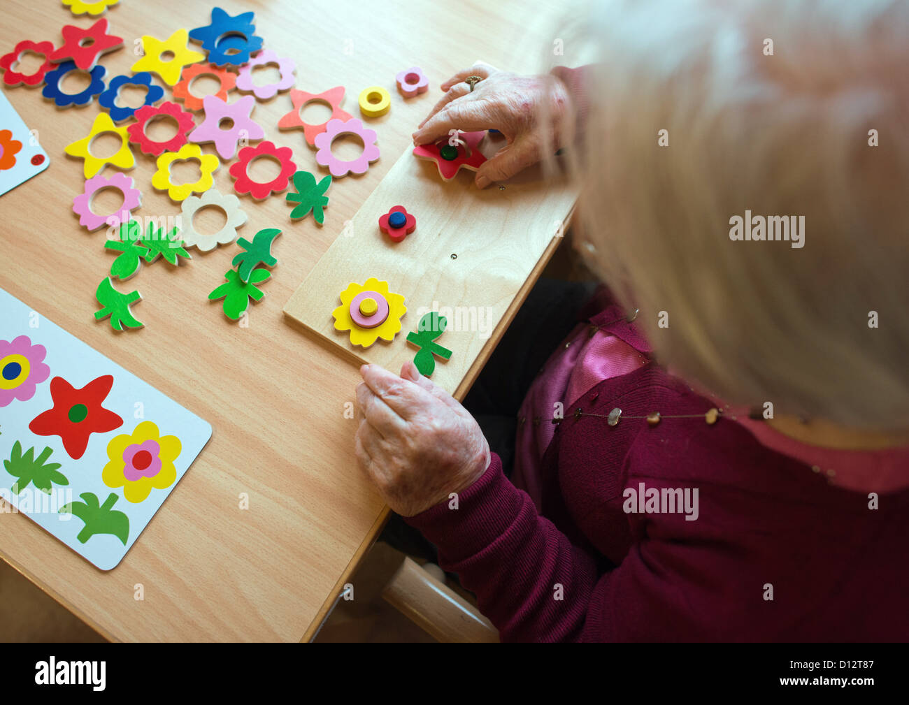 Eine Dement Frau versucht, herauszufinden, ein Puzzle in einem Seniorenheim in Frankfurt Oder, Deutschland, 29. November 2012. Foto: Patrick Pleul Stockfoto