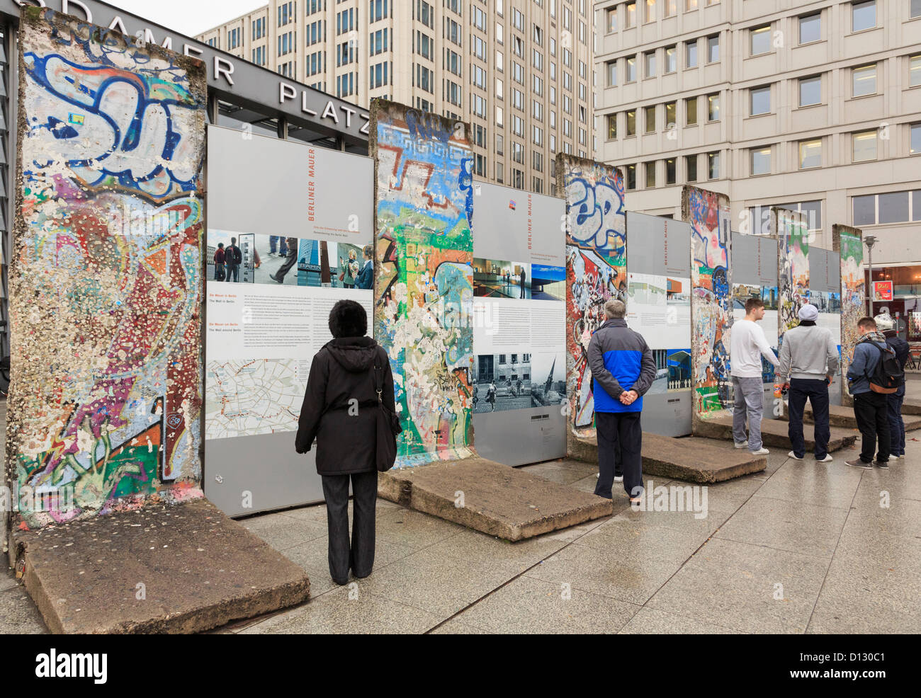 Street Scene mit Touristen Lesen von Informationen durch Teile der Mauer jetzt mit Graffiti im ehemaligen Todesstreifen am Potsdamer Platz, Berlin, Deutschland Stockfoto