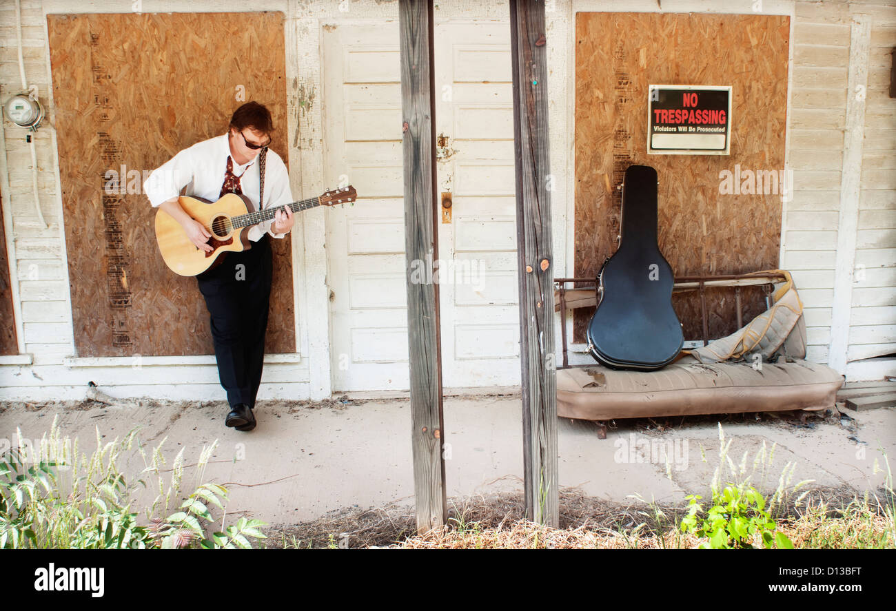 Ein Mann spielt eine Gitarre gegen ein verschalten, Dorfladen; Pittsboro, North Carolina Usa Stockfoto