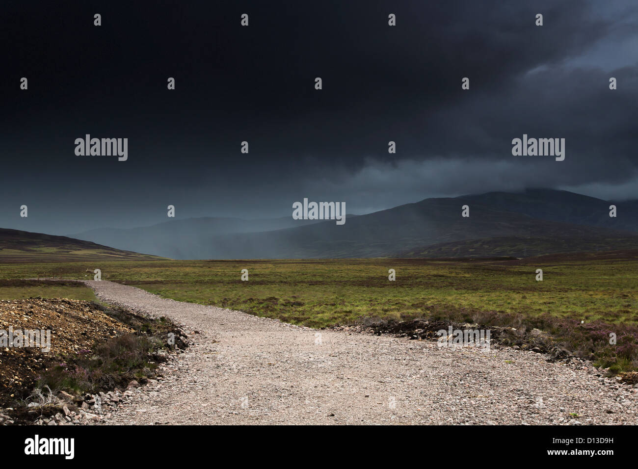 Ein Schotterweg unter dunklen Wolken; Highlands Schottland Stockfoto