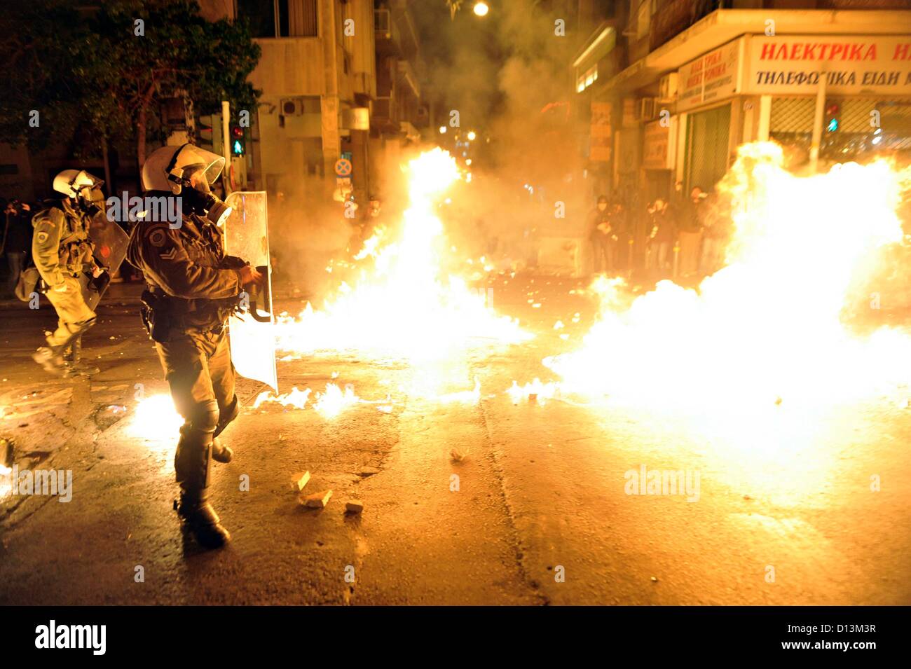 Athen, Griechenland. 6. Dezember 2012. Polizisten gehen Flammen des Molotov-Cocktails aus dem Weg bei Zusammenstößen zwischen Polizei und Demonstranten am Abend auf dem vierten Jahrestag des Todes von Alexandros Grigoropoulos in Athen Griechenland am 06.12.2012. Alexandros Grigoropoulos wurde am 06.12.2008 im Alter von 15 Jahren von einer Kugel aus einer Polizei Waffe getötet. Stockfoto
