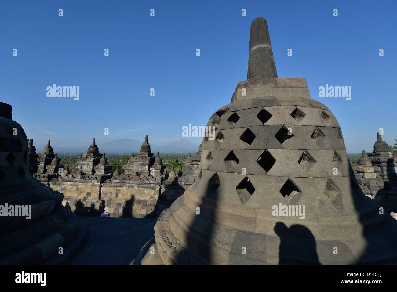 Die Stoupas am Borobudur mit Blick auf den Merapi im Hintergrund; Zentraljava, Indonesien. Stockfoto