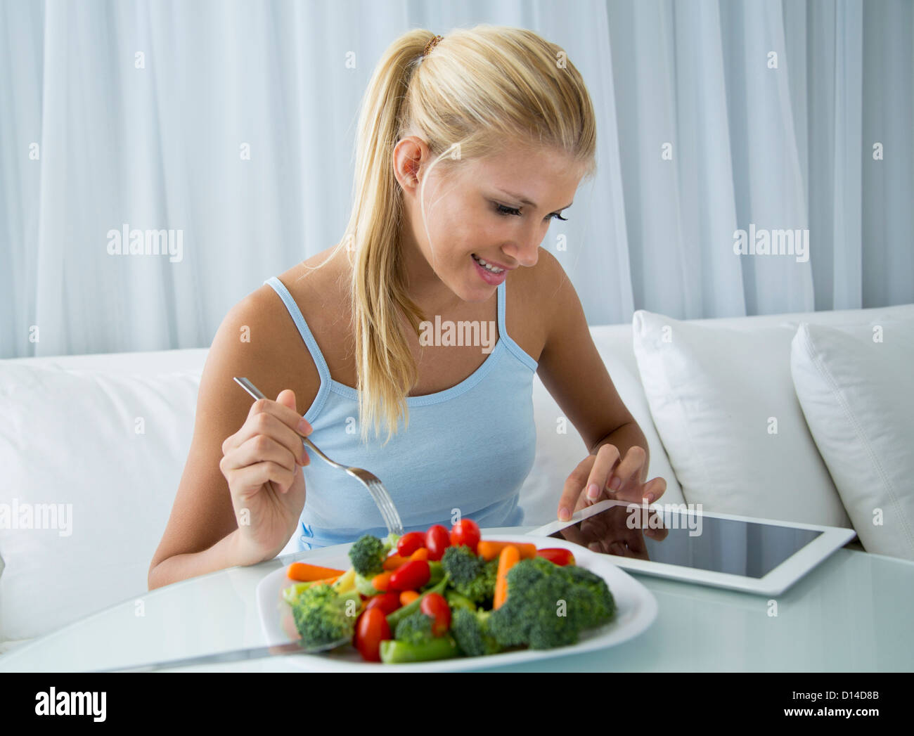 Frau mit Tablet PC und Essen Stockfoto