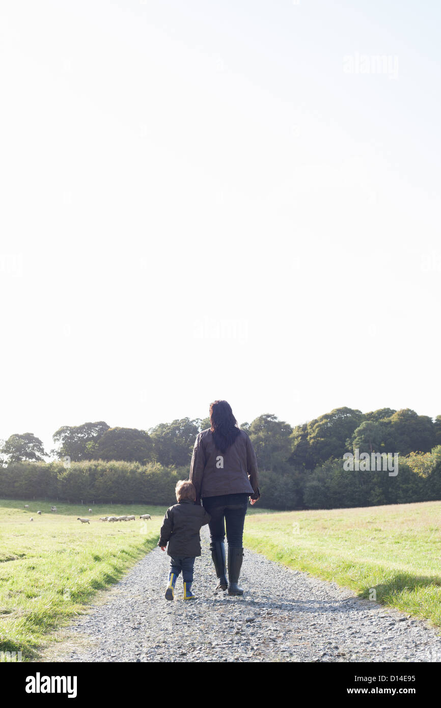 Mutter und Sohn gehen auf Feldweg Stockfoto