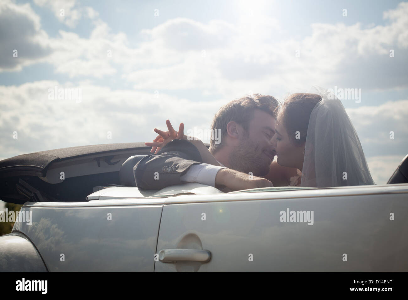 Brautpaar in einem Cabrio zu küssen Stockfoto