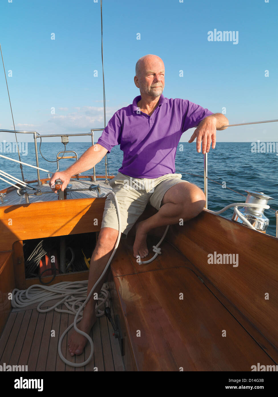 Ältere Mann Lenkung Segelboot Stockfoto