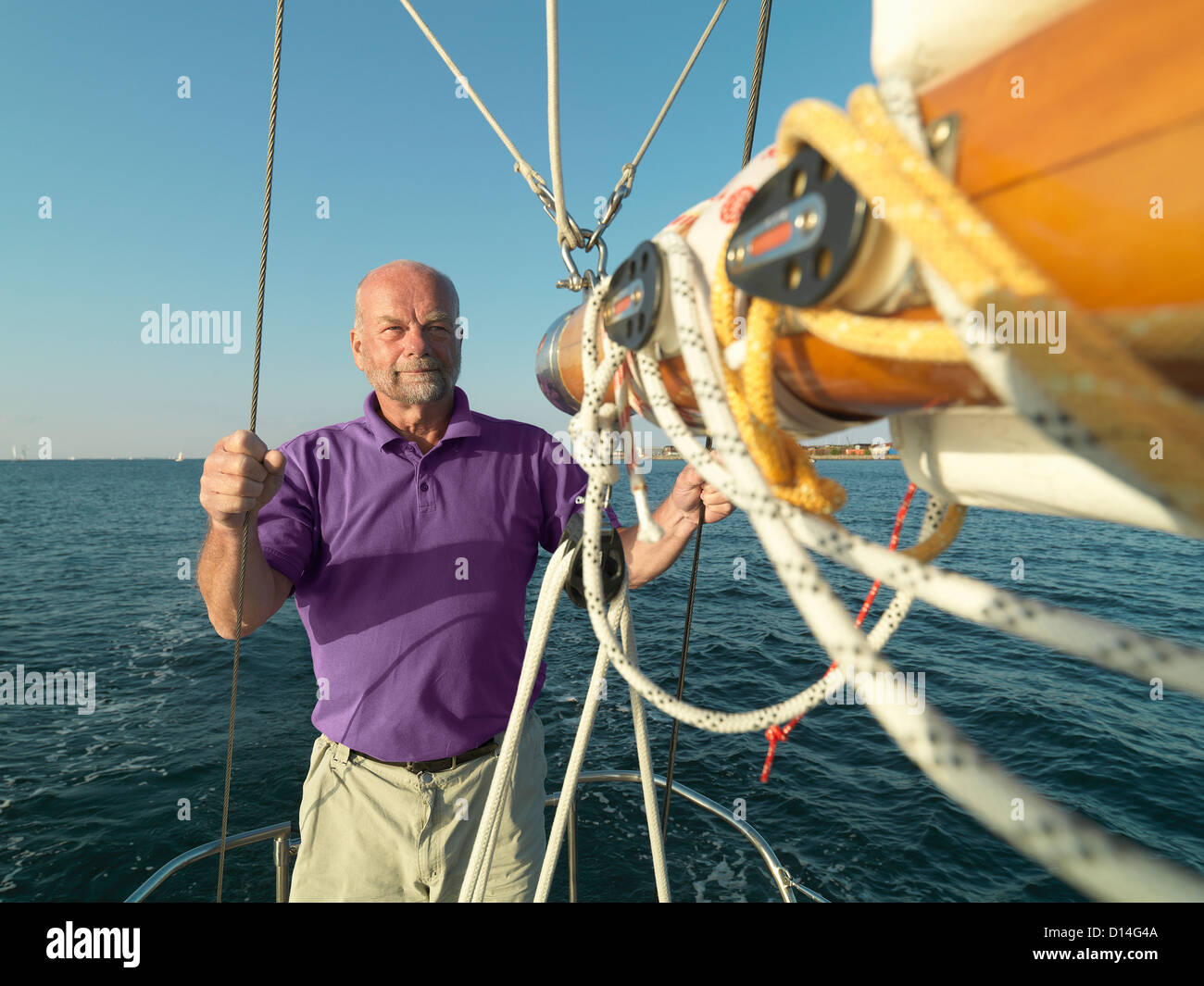 Mann, die Anpassung der Takelage auf Segelboot Stockfoto