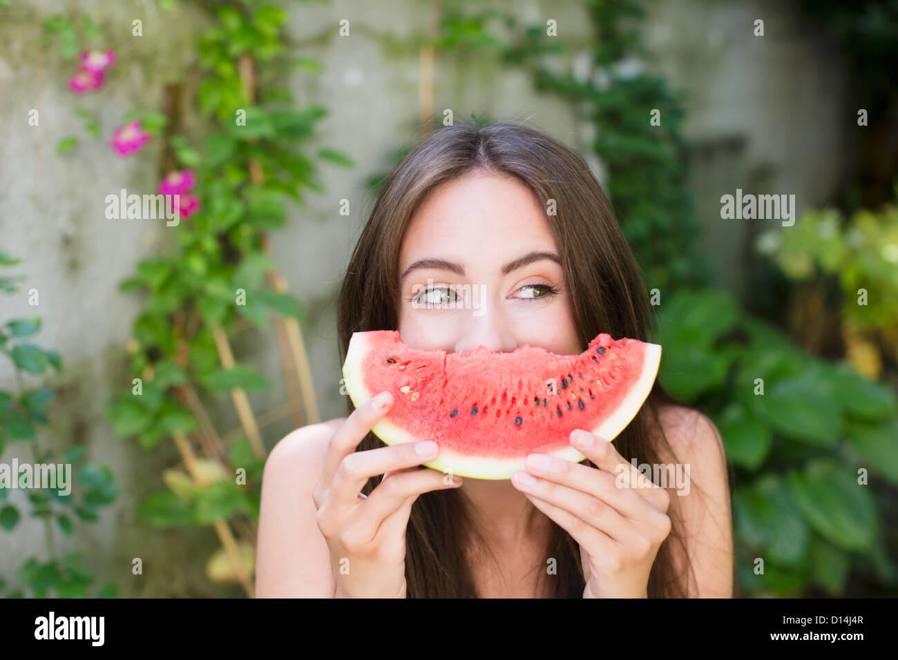Lächelnde Frau spielt mit Wassermelone Stockfoto