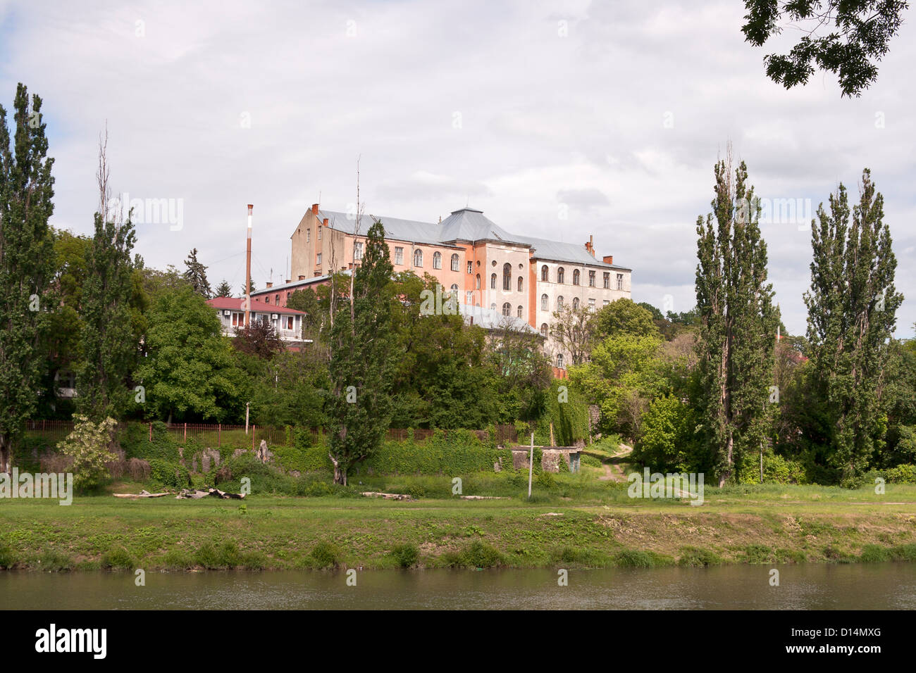 Früher Kloster, heute das Gebäude der Fakultäten der Staatsuniversität Uzhorod und Flussufer der Uzh. Ukraine. Stockfoto