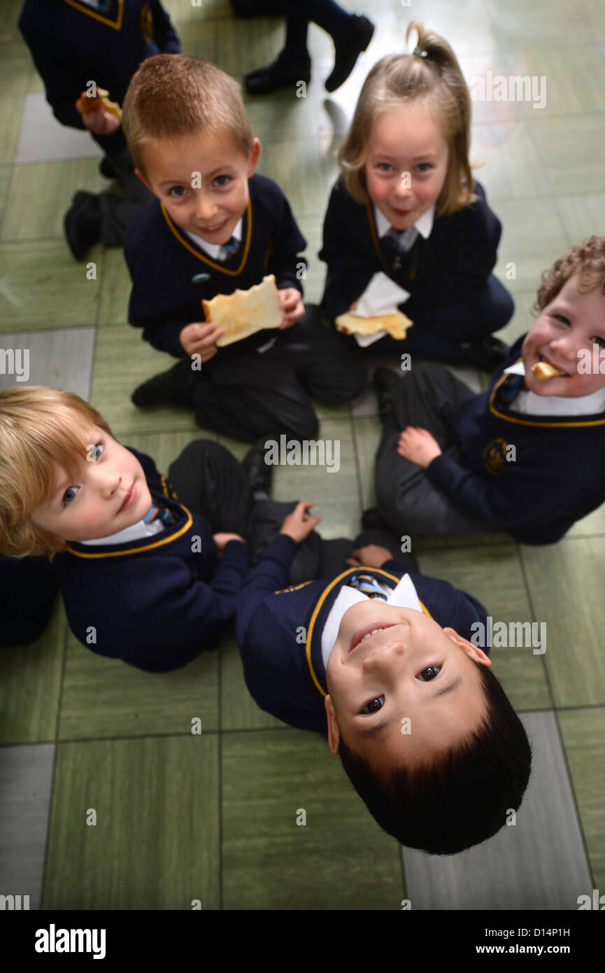 Ein Schuljunge Essen Toast nach Morgen Versammlung in Our Lady & St. Werburgh's katholische Grundschule in Newcastle-under-Lyme, St Stockfoto