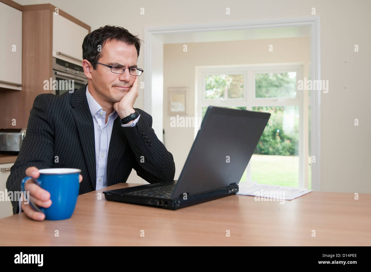 Geschäftsmann mit Laptop beim Frühstück Stockfoto