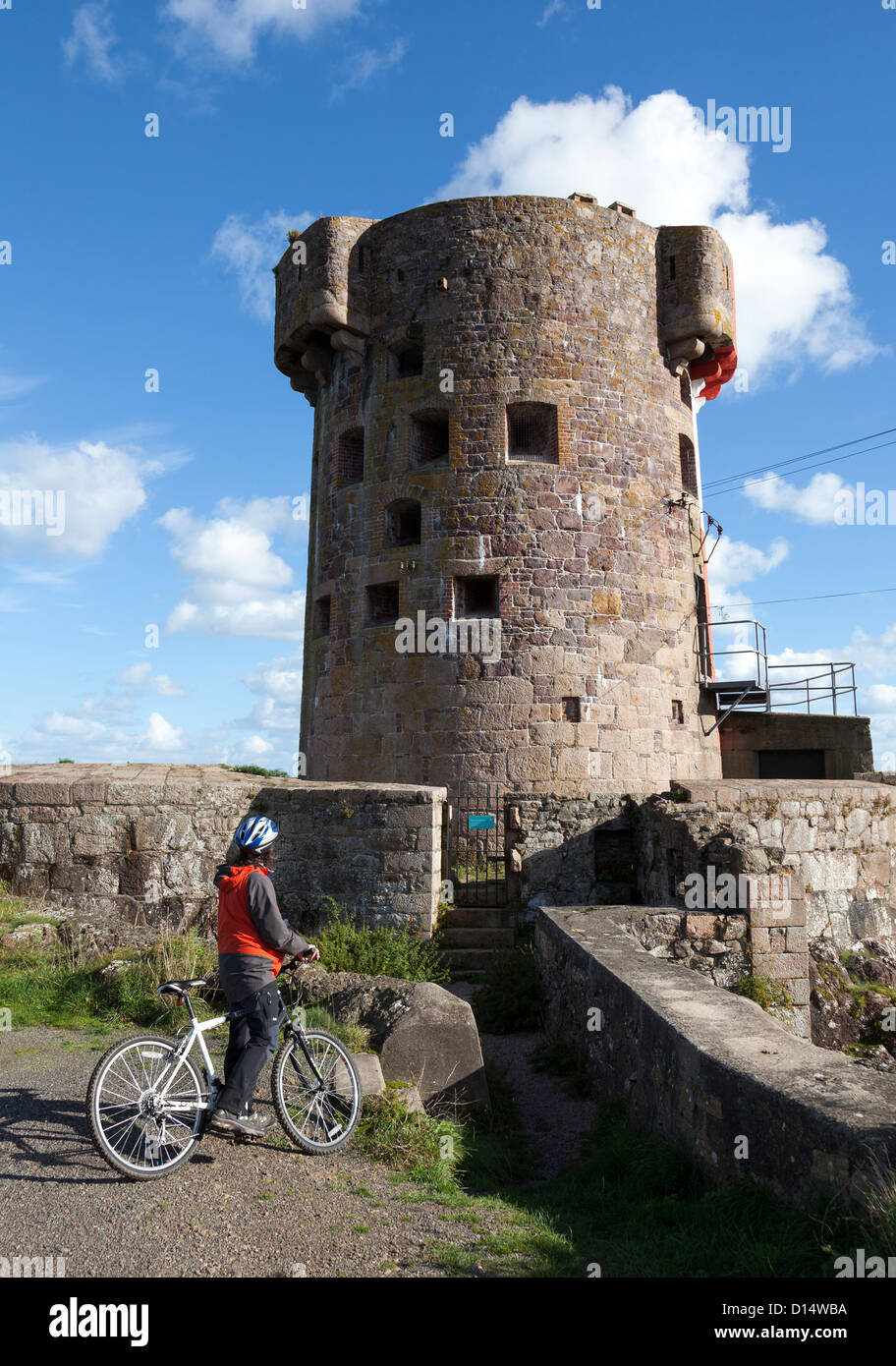 Frau Radfahrer am Archirondel Turm, le Havre de Fer, Ostküste Jersey, Kanalinseln, Großbritannien Stockfoto