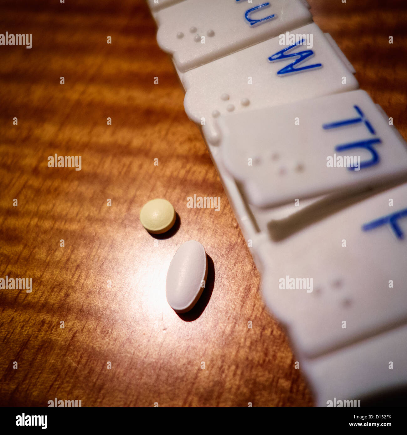Pillen und Pille-Veranstalter auf Holztisch Stockfoto
