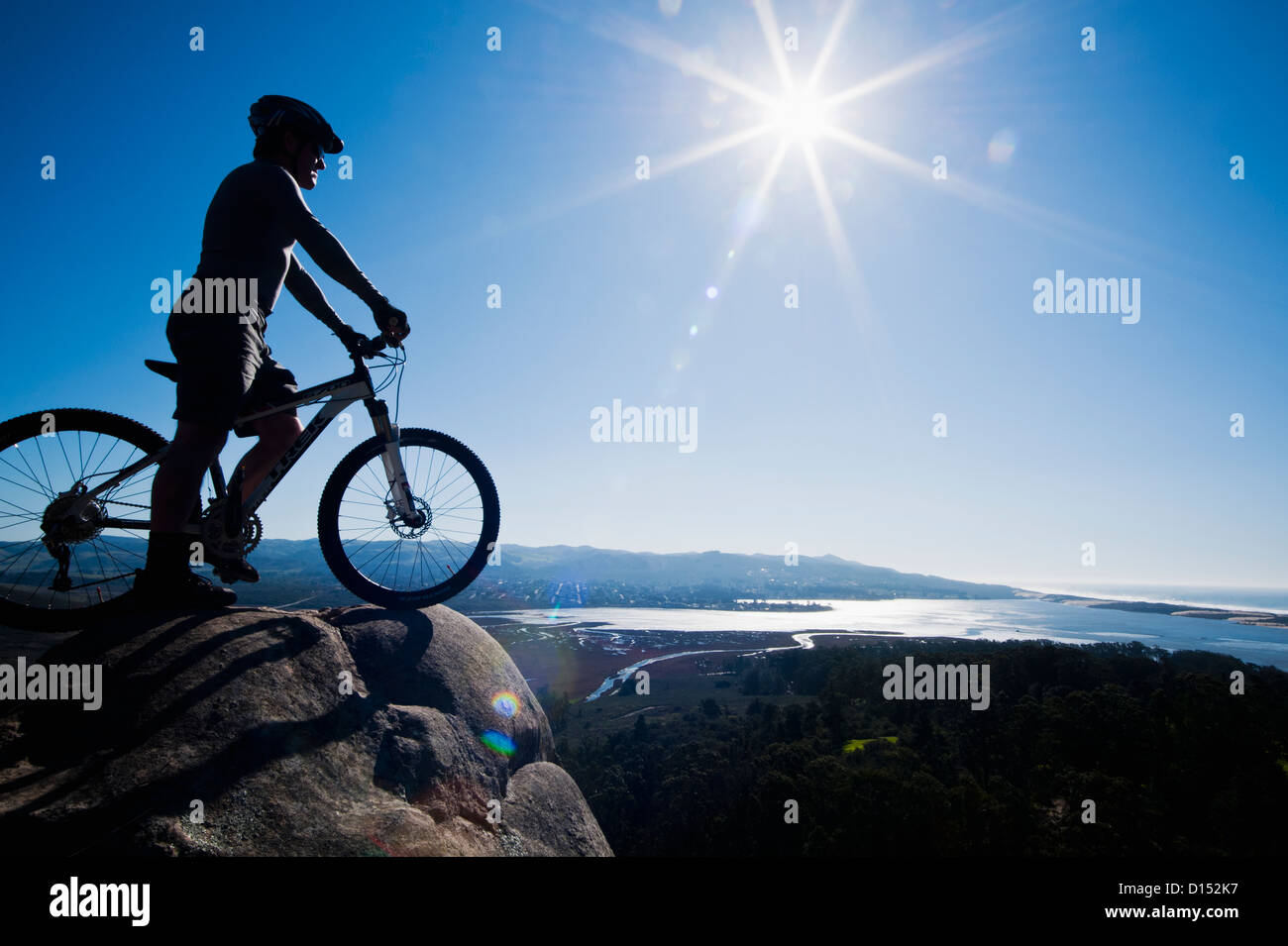 Kalifornien, Morro Bay State Park, Mann auf Fahrrad sieht über Morro Bay von Klippe. Stockfoto