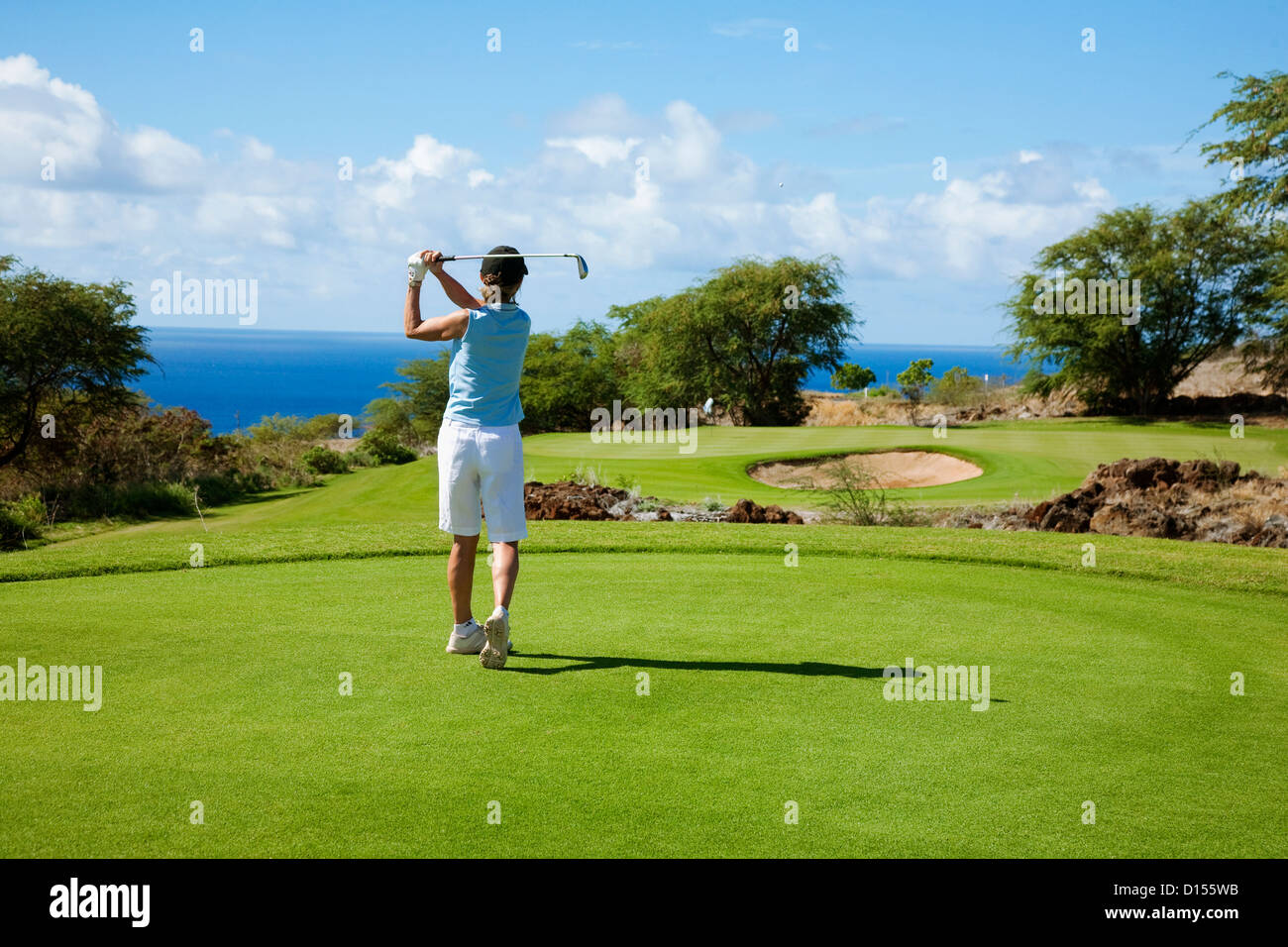 Hawaii, Lanai, Frau schlagen einen Abschlag auf die Herausforderung Manele Golfplatz beschossen. Stockfoto