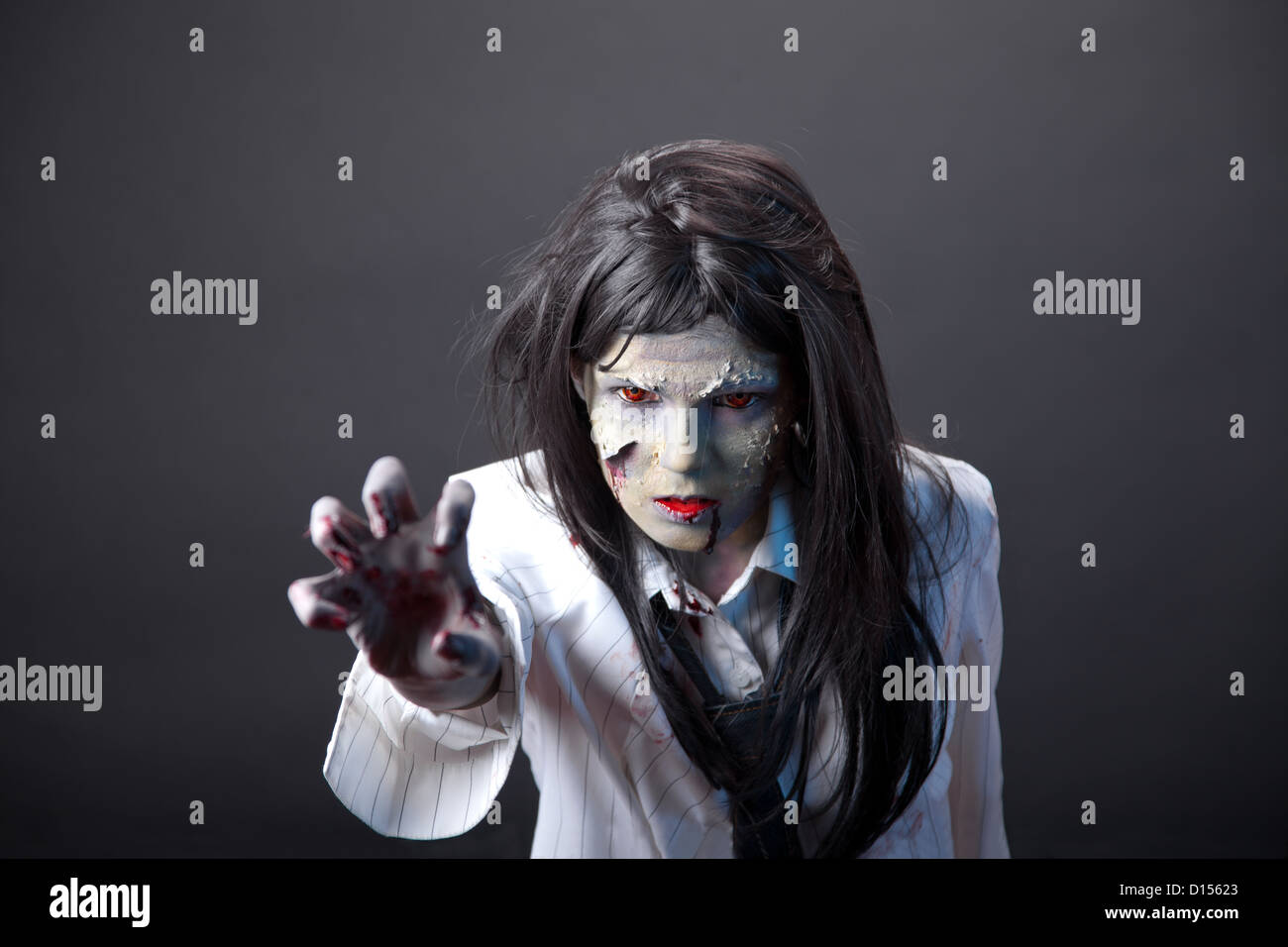 Aggressiven Zombie-Mädchen dehnen ihre Hand, professionelle Körperkunst und Kontaktlinsen Stockfoto