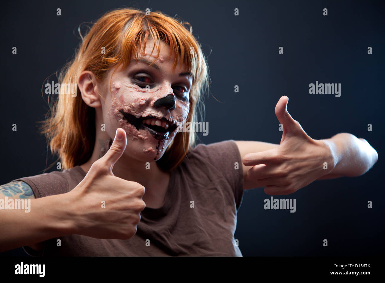 Happy Zombie Girl zeigt Daumen oben, Halloween Feiertag Stockfoto