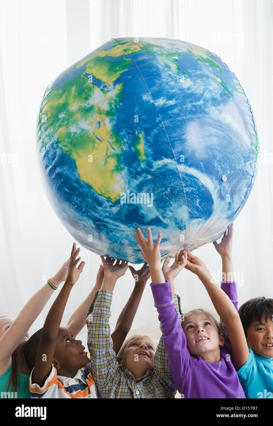 USA, New Jersey, Jersey City, Schulkinder (8-9) heben aufblasbare Globus Stockfoto