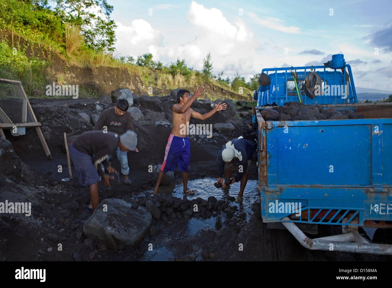 Philippinische Männer arbeiten, sammeln von Lava-Stein Stockfoto