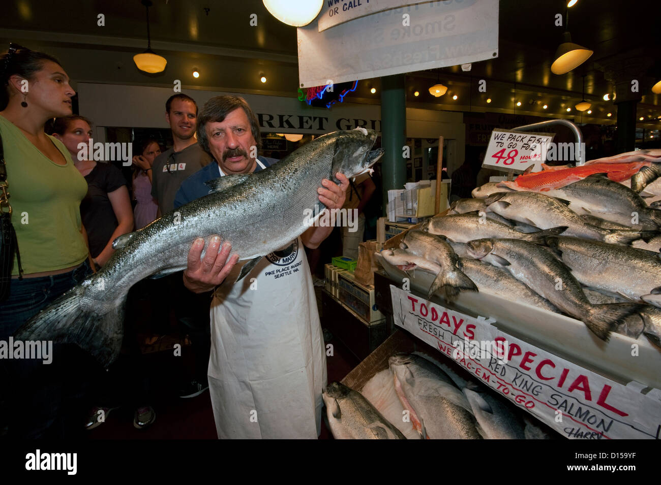 Fischhändler verkaufen Meeresfrüchte am Pike Place Market in der Innenstadt von Seattle, Washington, Vereinigte Staaten von Amerika. Stockfoto
