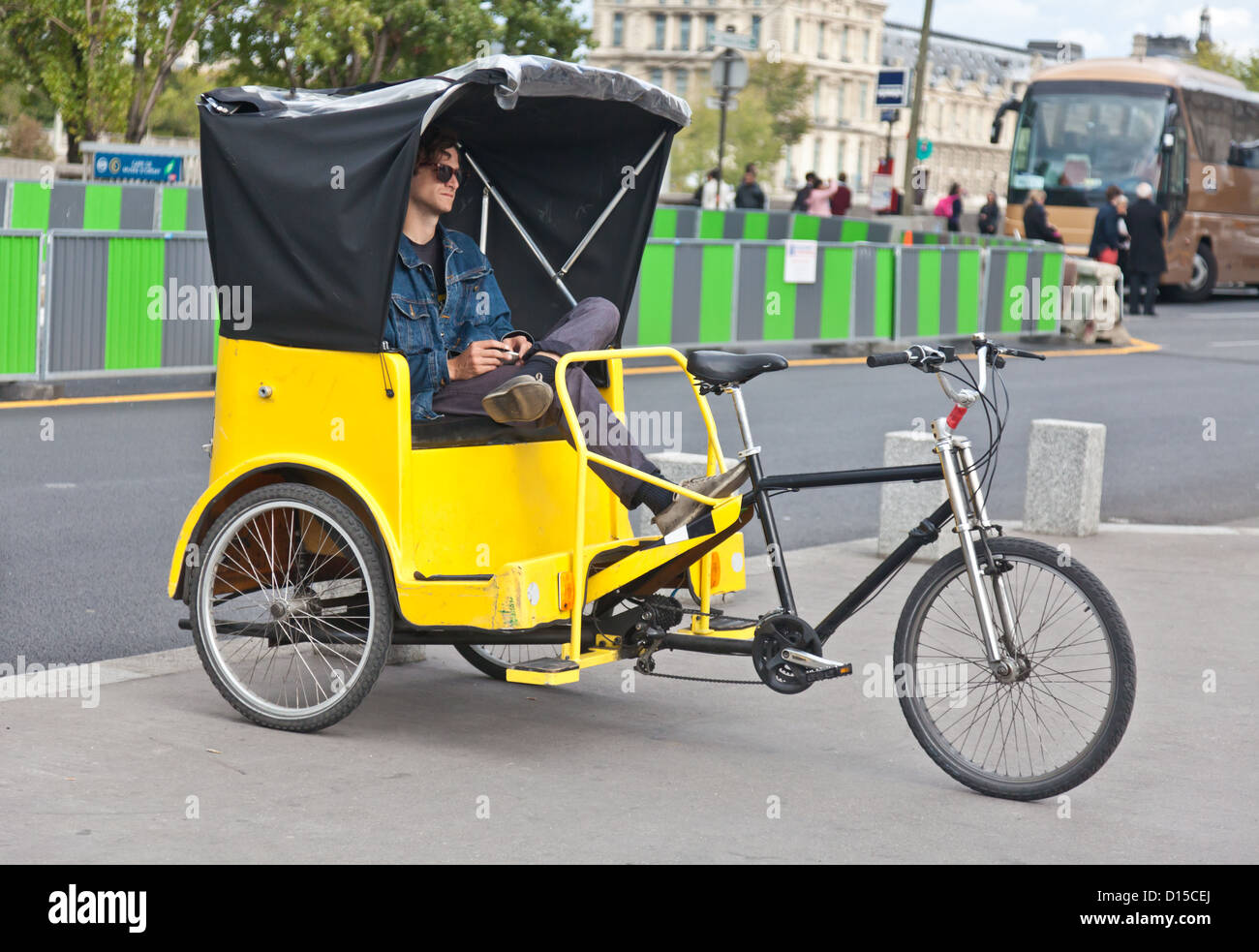 Fahrradrikscha mit Fahrer, wartet in Paris, Frankreich, Mitteleuropa üblich. Umweltfreundliche Verkehrsmittel; Stockfoto