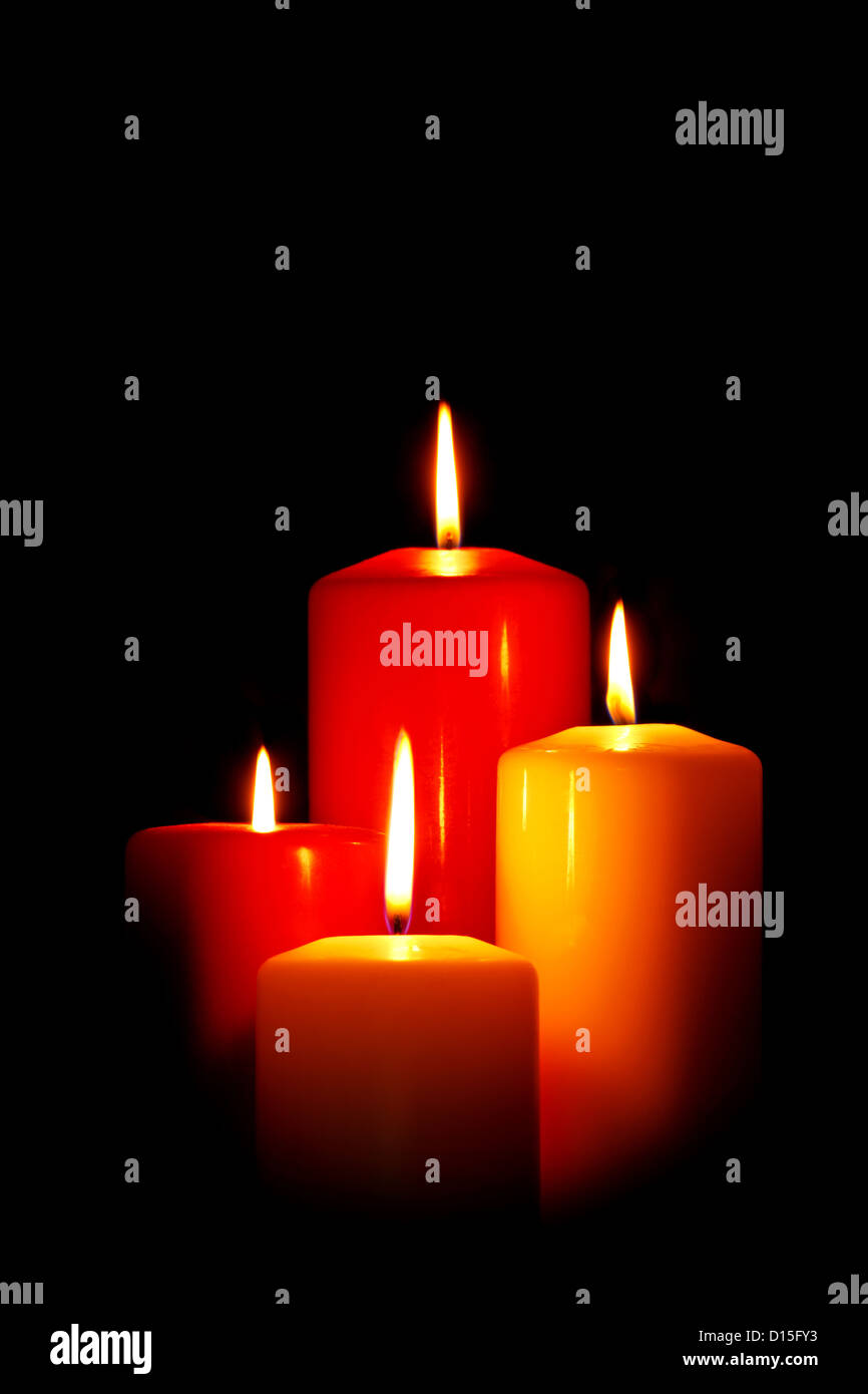 Vier rote und weiße Kerzen Weihnachten auf einem schwarzen Hintergrund. Stockfoto