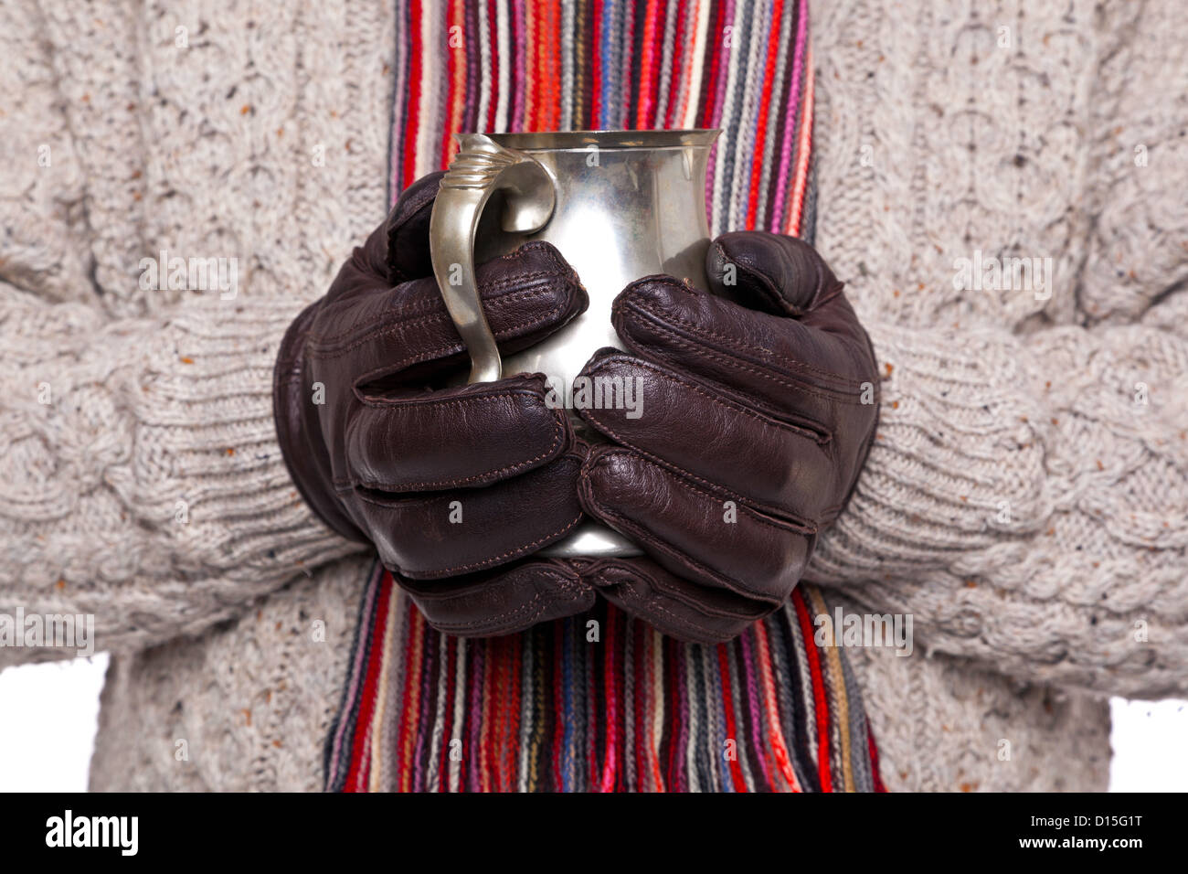 Nahaufnahme eines Mannes in wollene Pullover, Schal und Handschuhe halten  einen Zinn Becher Glühwein. Schwerpunkt liegt auf den Händen und Krug  Stockfotografie - Alamy