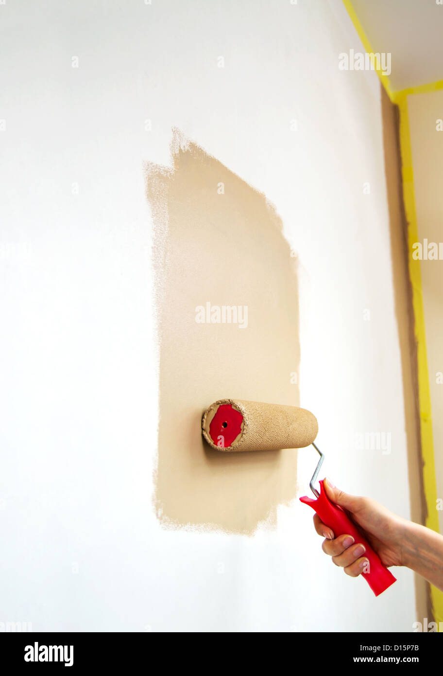 Walze mit brauner Farbe an der Wand Stockfoto