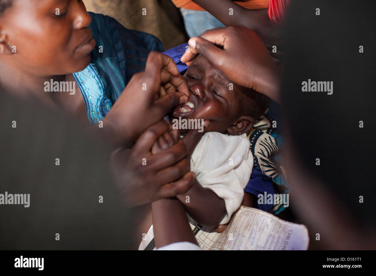 Ein Kind erhält eine Entwurmung Medikamente eine Immunisierung Outreach Camp in Kitugutu Dorf, Kyenjojo District, Uganda. Stockfoto