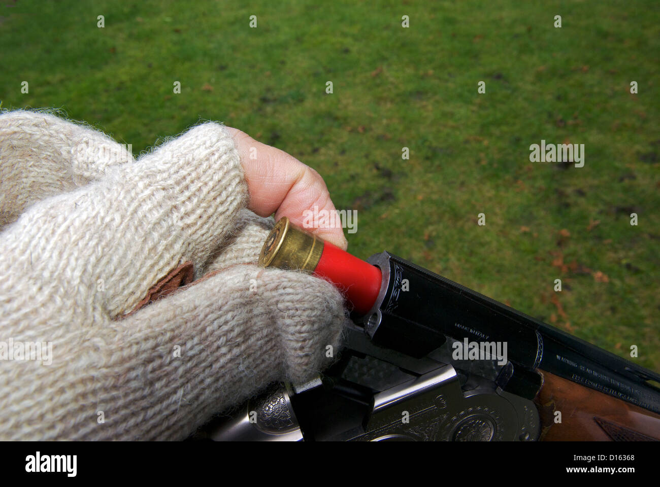 Hand in gestrickten wollenen fingerlosen Handschuh laden 28 gauge Shotgun Shell Patrone in Kammer Stockfoto