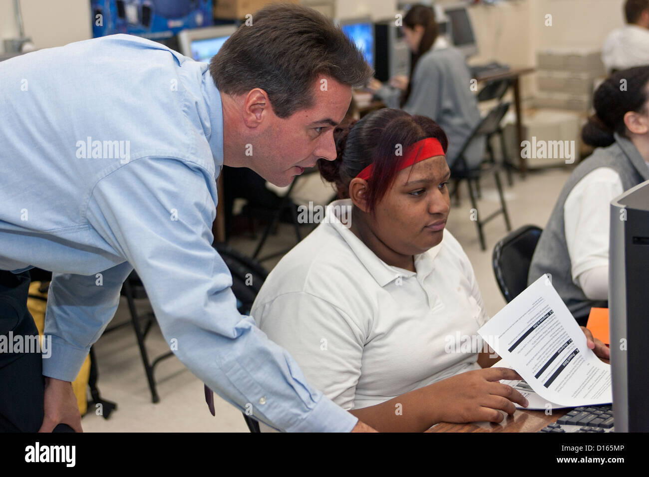 Lehrer hilft ein Student mit dem computer Stockfoto