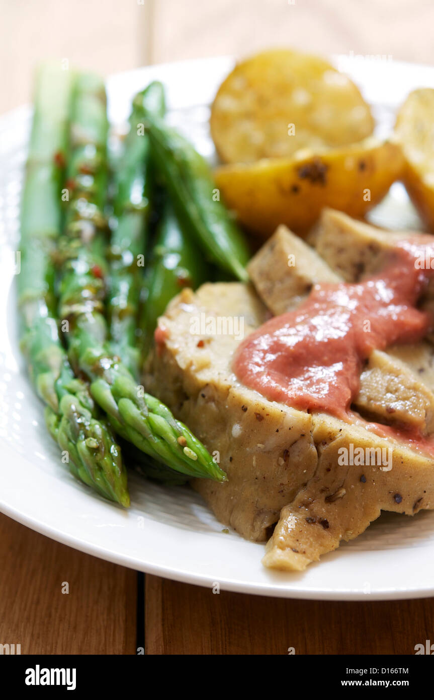 Seitan-Scheiben mit Rhabarber Senf, grünem Spargel und Bratkartoffeln. Stockfoto