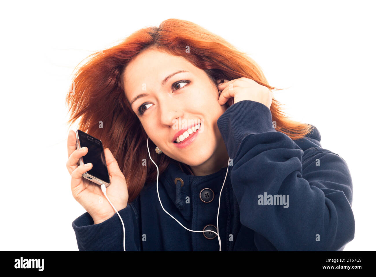 Junge Frau in blauen Hoodie Smartphone halten und hören Musik, isoliert auf weißem Hintergrund. Stockfoto