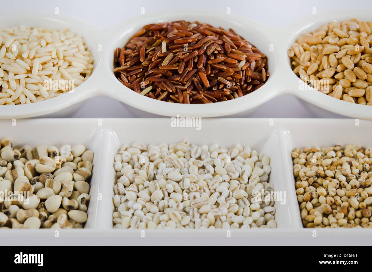 Korn und Getreide festgelegt, Reis, Roter Reis, Weizen, job's-Tränen, Gerste und Hirse Körner auf Schüssel weiß Stockfoto