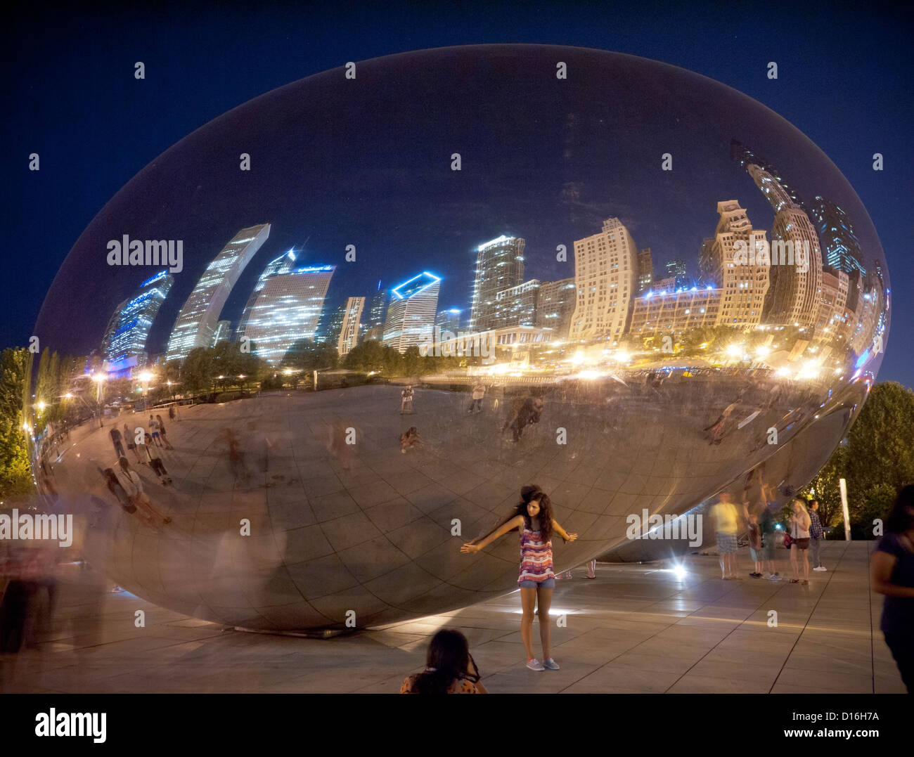 Durchführung der Welt auf dem Rücken.  Ein hübsches Modell zu Cloud Gate (The Bean) in der Nacht im Millennium Park in Chicago, Illinois. Stockfoto